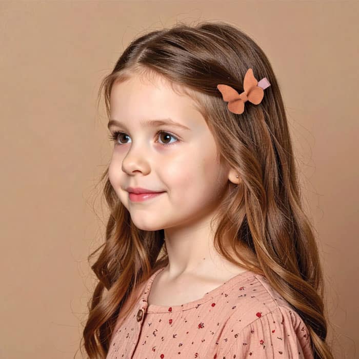 Petite fille portant une barrette papillon anti-glisse, accessoire cheveux enfant poétique et élégant pour l’automne-hiver