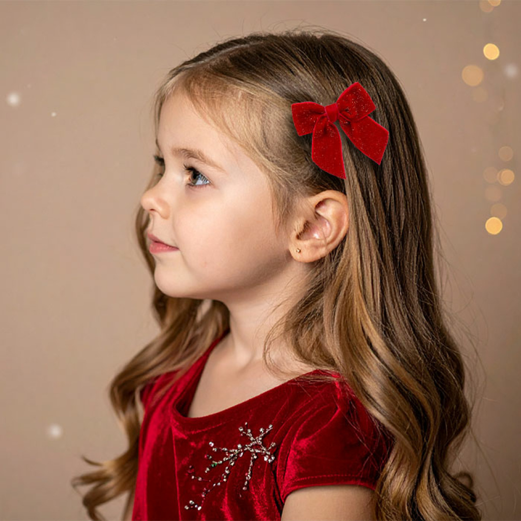 Petite fille portant une barrette grand nœud rouge pailleté, coiffure de Noël féérique – Chouette & Papillon