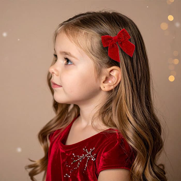 barrette-fille-noel-noeud-velours-rouge-paillettes Petite fille portant une barrette grand nœud rouge pailleté, coiffure de Noël féérique – Chouette & Papillon